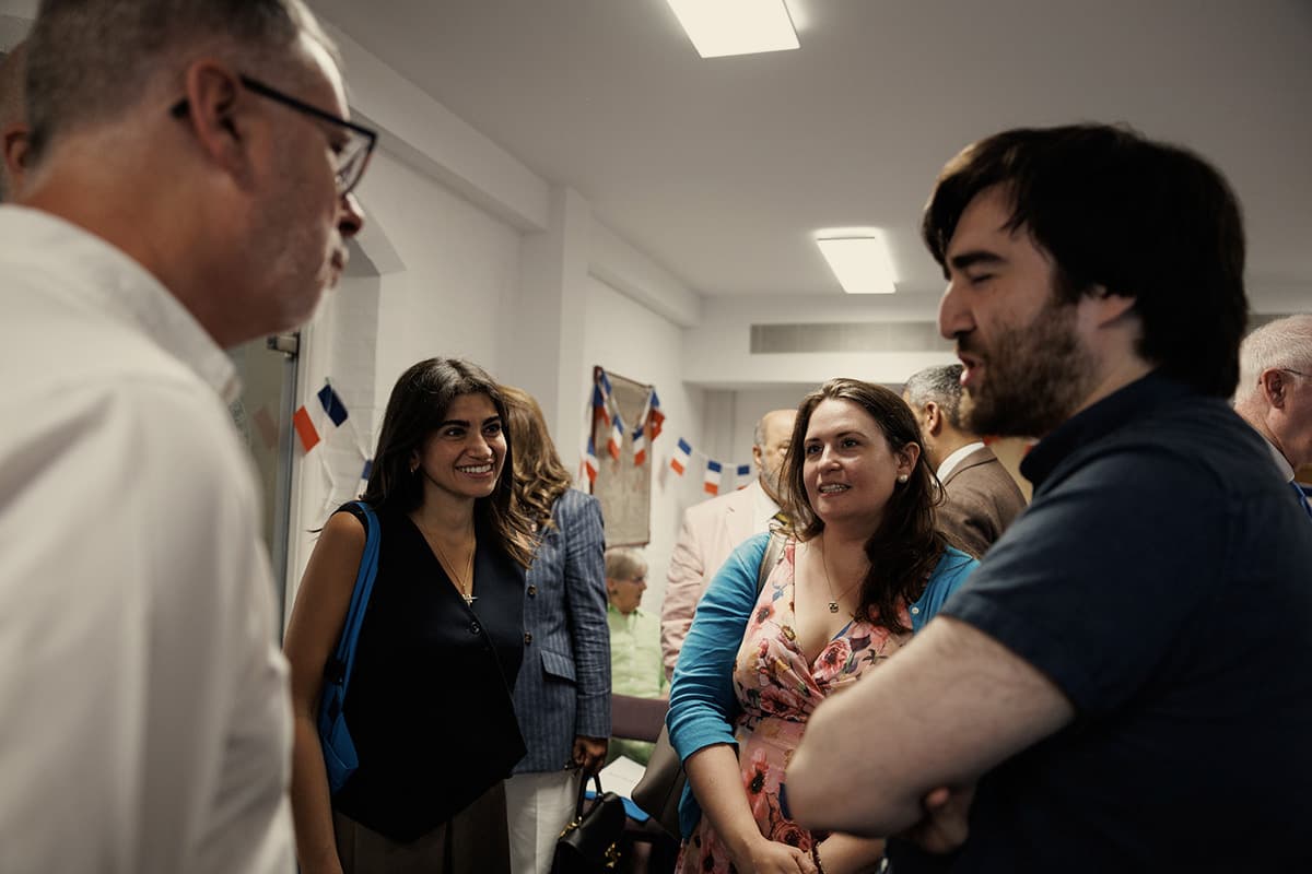 Guests talking together at a public engagement event, with bunting strung across the room